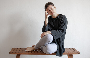 Young woman looks tired, unhealthy, upset copy space.