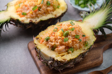 Carved pineapple stuffed with fresh pineapple tomato sauced seafood fried rice.