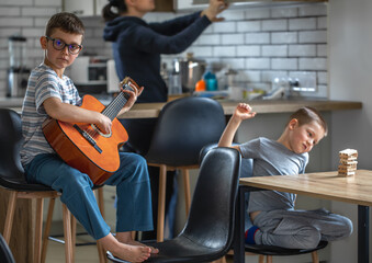 Two little boys are doing their hobbies at home during breaktime.