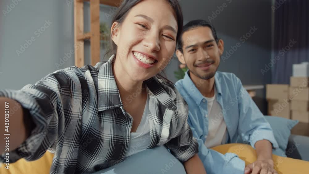 Canvas Prints happy young asian couple man and woman sit couch use looking at camera video call with friends and f