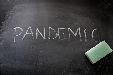 erasing pandemic, hand written word on blackboard being erased concept