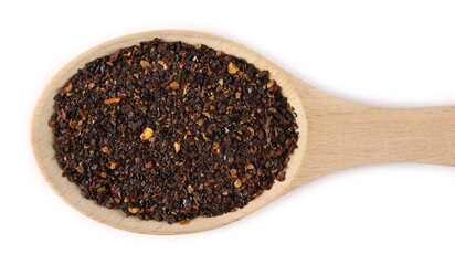 Dried, roasted and ground ancho chili pepper flakes in wooden spoon isolated on white background, top view