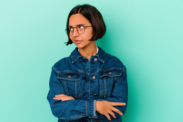 Young mixed race woman isolated on blue background dreaming of achieving goals and purposes