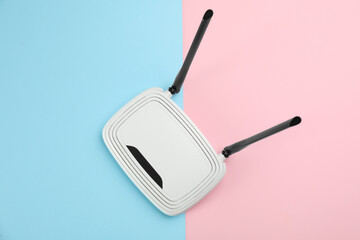 Modern Wi-Fi router on color background, top view