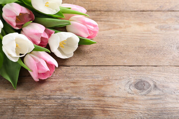 Obraz na płótnie Canvas Beautiful pink spring tulips on wooden background, space for text
