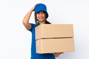 Young delivery brunette girl over isolated white background frustrated and takes hands on head