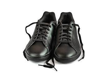 A pair of new black leather sneakers on a white insulated background. Male black sporty shoes