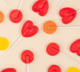 Various lollipops on pastel beige background. Creative pattern idea.