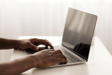 African american male hands typing on laptop keyboard, cropped, closeup. Modern technologies and business concept