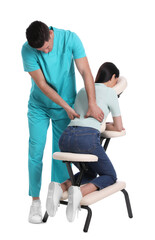 Woman receiving massage in modern chair on white background