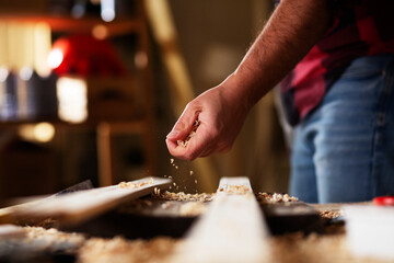 Young male carpenter working in workshop. Carpenter working on wood craft at workshop.