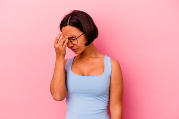 Young mixed race woman isolated on pink background having a head ache, touching front of the face.