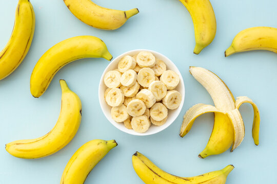 Many banana slices with whole bananas. Top view