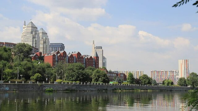 ars go along the street against the background of buildings, towers, skyscrapers, park in the city  Dnepropetrovsk, Dnipro, Ukraine. Beautiful view from Monastyrsky Island in spring and summer