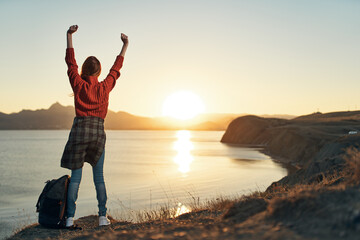 Fototapeta premium woman tourist with raised up hand landscape sunset vacation