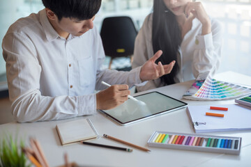 Asian designer work together creativity in the work using a tablet at the office.