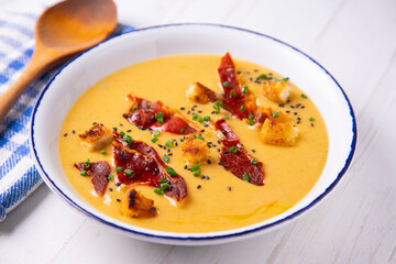 Hot vegetable cream with ham and olive oil 