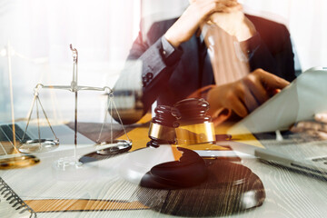 Justice and law concept.Male judge in a courtroom with the gavel, working with, computer and docking keyboard, eyeglasses, on table in morning light