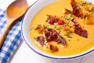 Hot vegetable cream with ham and olive oil 