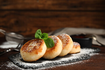 Delicious cottage cheese pancakes with mint and icing sugar on wooden table