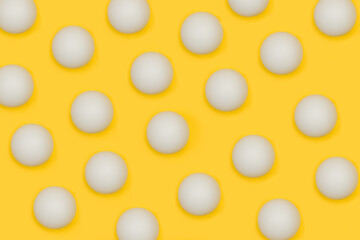 Muchas pelotas blancas de tenis de mesa ping pong sobre un fondo amarillo liso y aislado. Vista superior. Concepto: Deportes