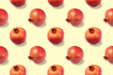 Seamless pattern of ripe red healthy pomegranates on yellow background