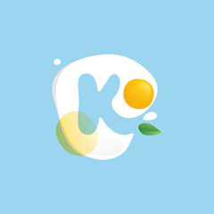 Letter K logo on a Fried Egg with green leaf and splashes.