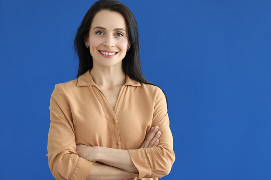 Portrait of smiling young woman on blue background