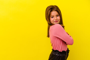 Little caucasian girl isolated on yellow background smiling confident with crossed arms.