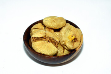 dried figs fruit in a brown wooden bowl isolated on a white background