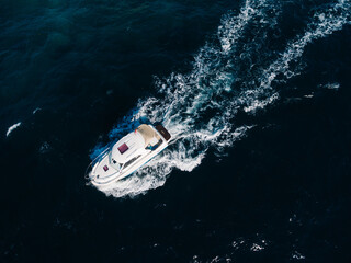 White motorboat floats on the open sea. View from above