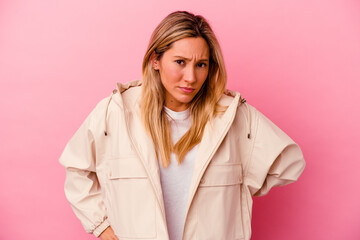 Young mixed race woman isolated on pink background blows cheeks, has tired expression. Facial expression concept.