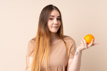 Young caucasian woman holding an orange