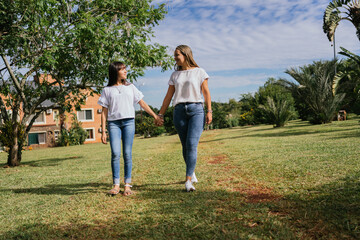 Mother and daughter walking hand in hand.