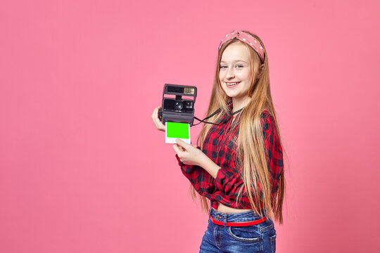 Hipster photographer young woman making photo using retro camera. Funny Girl with instant camera smiling on shot.