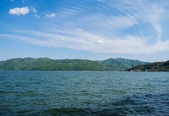 Danube river, with blue water. Mountains covered with vegetation in the distance.