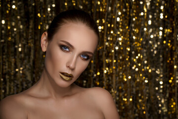 Magic Girl Portrait in Gold. Golden Makeup, close-up portrait in studio shot, color