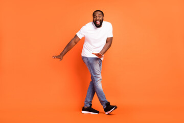 Fototapeta na wymiar Full length photo of funky afro american young man dance good mood smile isolated on orange color background
