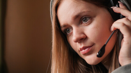 Portrait of a young girl in a hoodie and with a headset. Call center worker