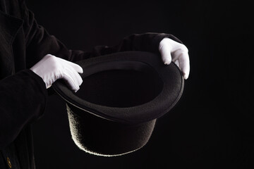 Hand gestures. illusionist holds a hat in his hands and shows magic and tricks.