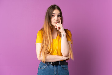 Young caucasian woman isolated on purple background and thinking