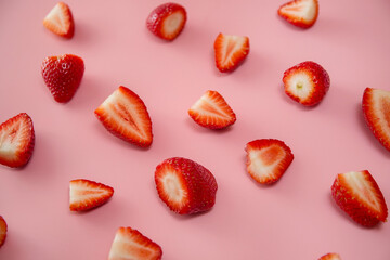 Delicious juicy ripe red strawberries on a pink background. Close-up shot of strawberries on a grater. Berry pattern