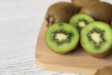Juicy ripe kiwi on a wooden table, space for text