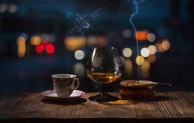 Background image of a wooden bar by the window in a pub with a glass of cognac, a smoking cigarette...