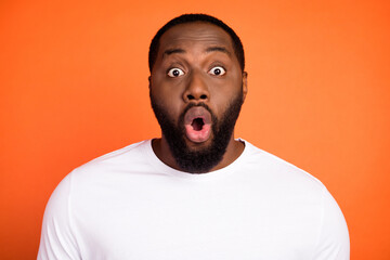 Portrait of attractive amazed guy pouted lips incredible news reaction isolated over bright orange...