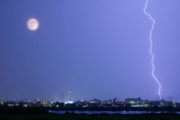 満月の横に落ちる雷