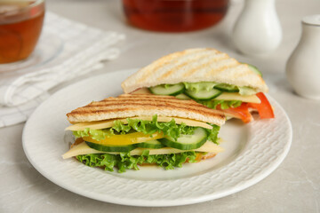 Delicious sandwiches with vegetables and cheese on table, closeup