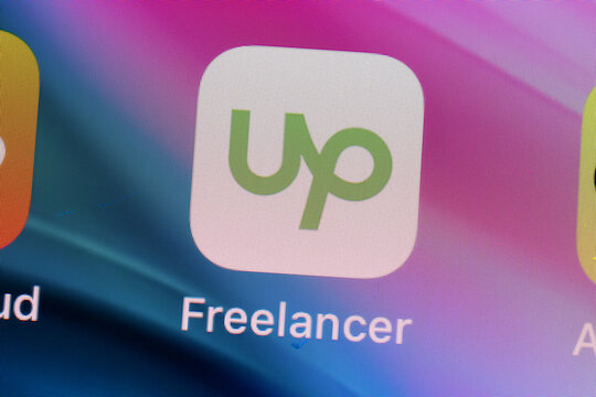 New York, USA - 26 April 2021: UpWork Freelancer app logo on phone screen close-up top view, Illustrative Editorial.