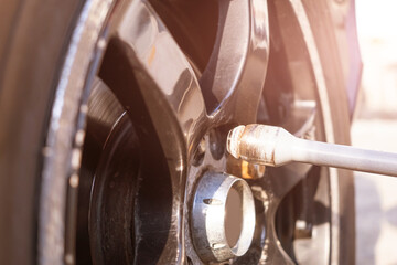 Car wheel replacement. Self-service tire fitting concept. Using a wheel wrench to twist the wheel nuts.