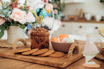 Easter decor on a wooden table and Easter bunny cake, Easter cake on a wooden tray, spring flowers, sweet table for the holiday, Easter holiday